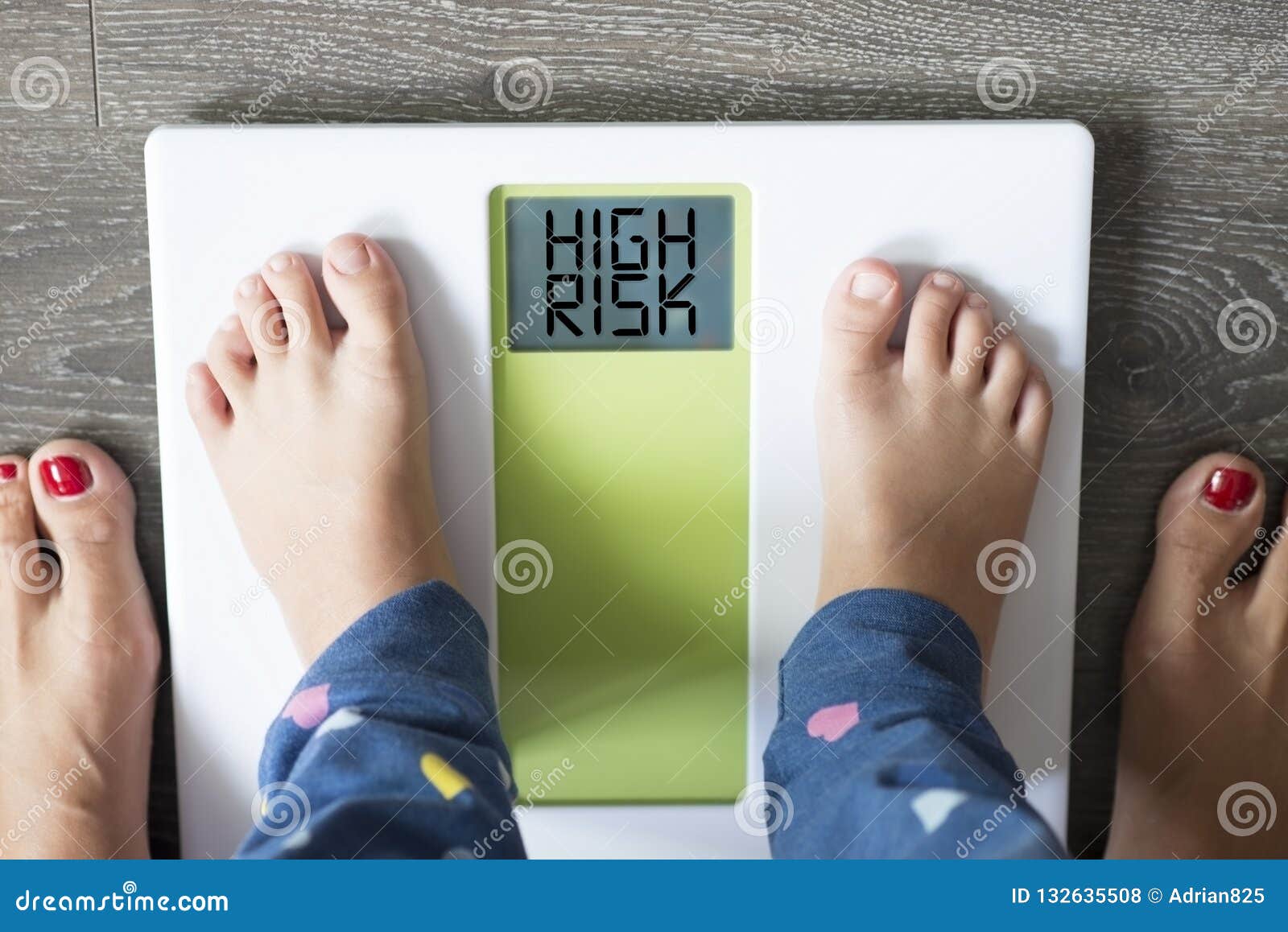 childhood obesity high risk for health problems with childÃ¢â¬â¢s feet on weight scale under the supervision of his mother